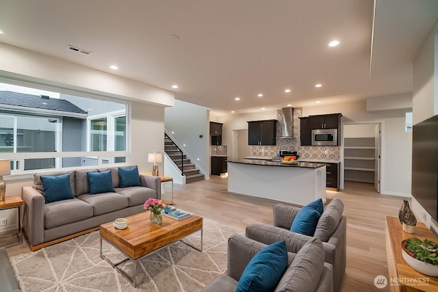 living area featuring light wood finished floors, stairs, visible vents, and recessed lighting