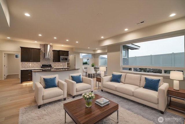 living room featuring plenty of natural light, recessed lighting, visible vents, and light wood-style floors