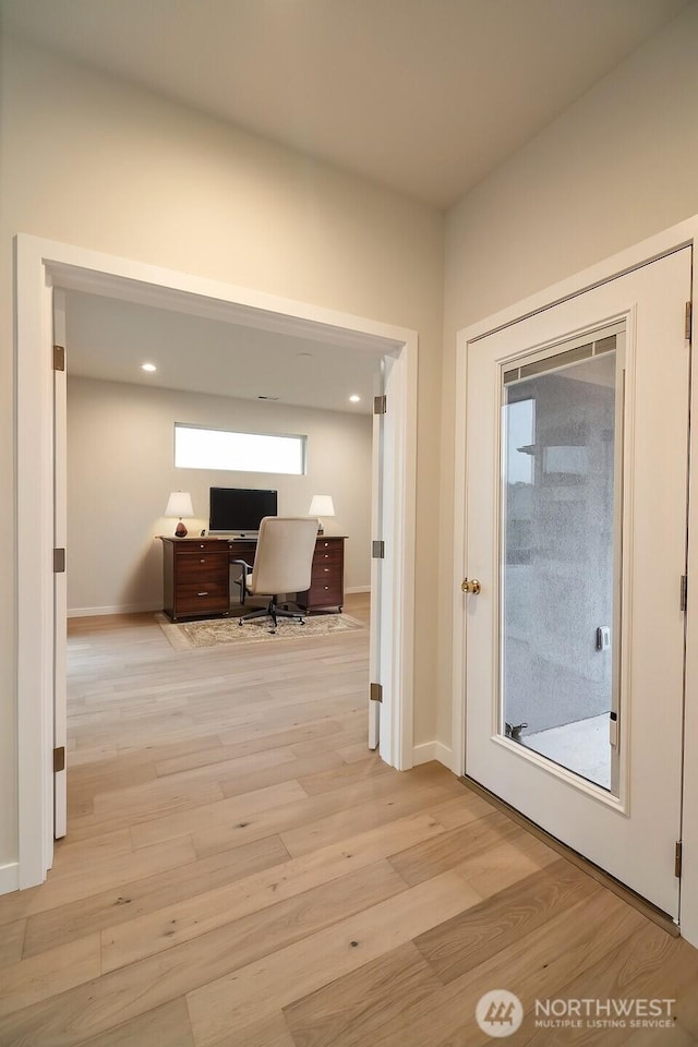 interior space featuring recessed lighting, baseboards, and light wood finished floors