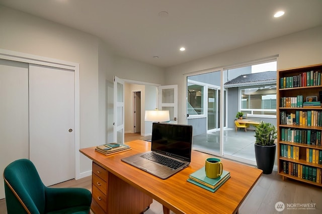 office area with light wood finished floors and recessed lighting