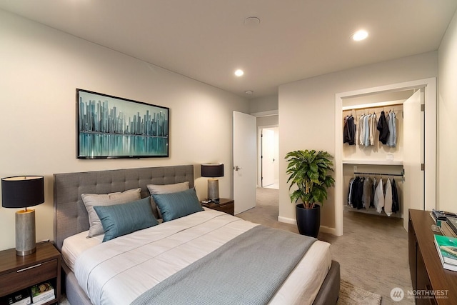 carpeted bedroom with a closet, a walk in closet, and recessed lighting