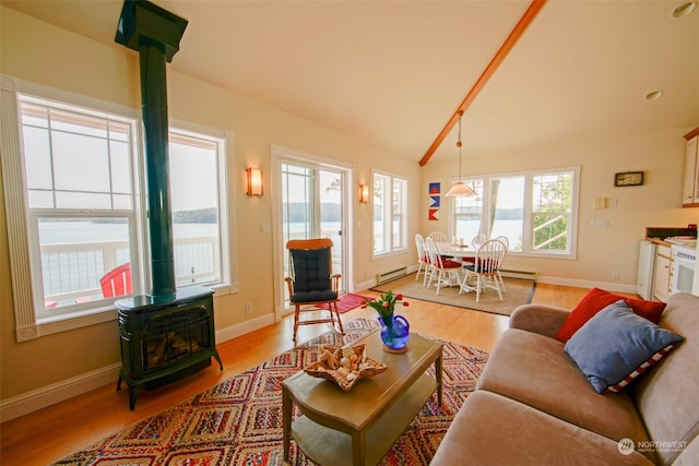 living room with baseboards, a wood stove, light wood-type flooring, vaulted ceiling, and a baseboard heating unit