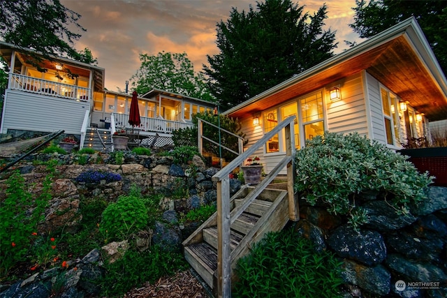 property exterior at dusk featuring stairs