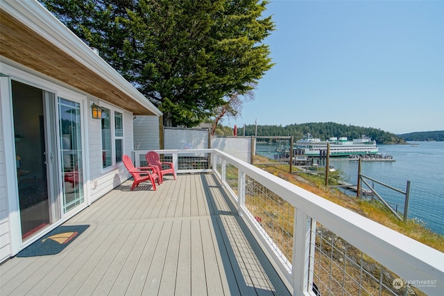 wooden terrace featuring fence and a water view