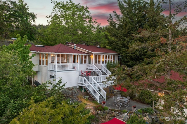 back of property with a patio area and stairway