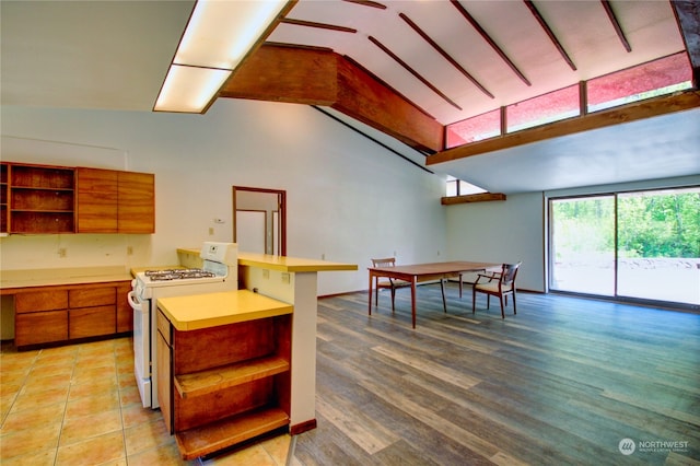 kitchen featuring vaulted ceiling with beams, light hardwood / wood-style flooring, and white gas stove