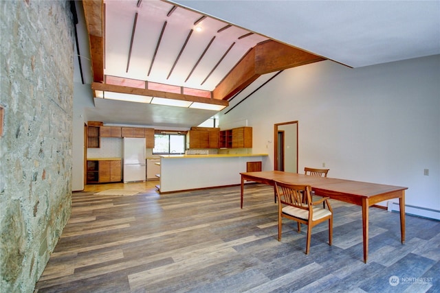 dining area featuring dark hardwood / wood-style flooring, lofted ceiling with beams, and a baseboard heating unit