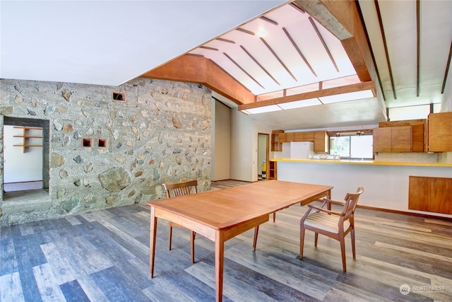 dining area with dark hardwood / wood-style flooring and vaulted ceiling with beams