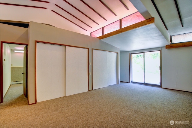 spare room with lofted ceiling, baseboard heating, and light carpet