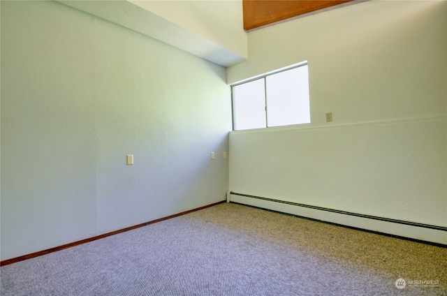 empty room featuring light carpet and a baseboard heating unit