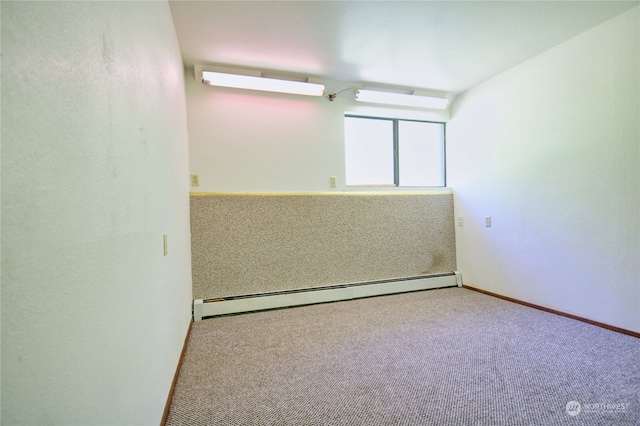 spare room featuring a wall unit AC, a baseboard heating unit, and carpet flooring