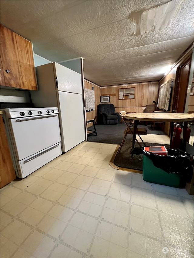 kitchen featuring a textured ceiling, light tile flooring, and white range oven