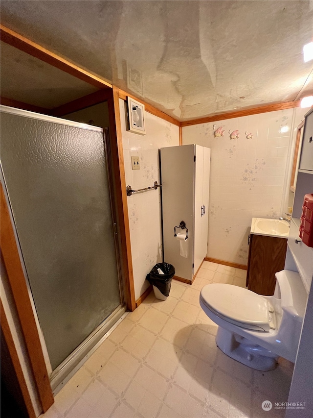 bathroom with toilet, vanity, a shower with shower door, and tile flooring