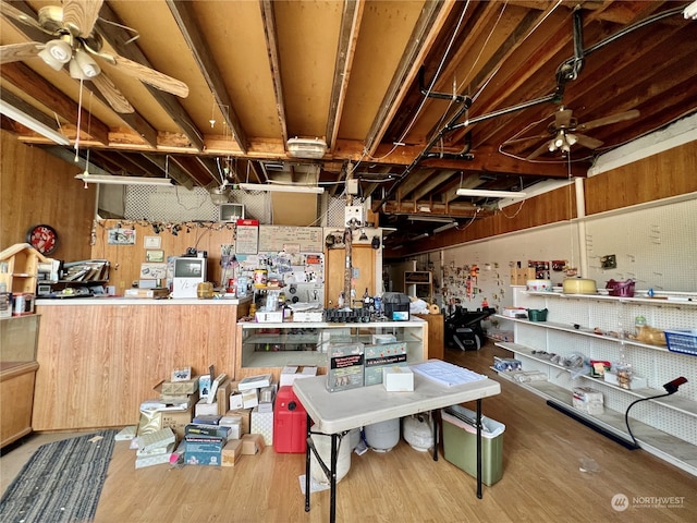 miscellaneous room featuring ceiling fan, a workshop area, and hardwood / wood-style flooring