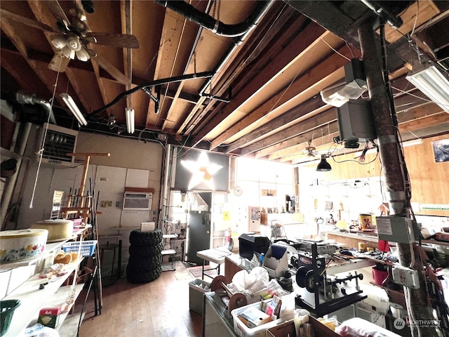 misc room featuring a wall mounted air conditioner, wood-type flooring, and ceiling fan