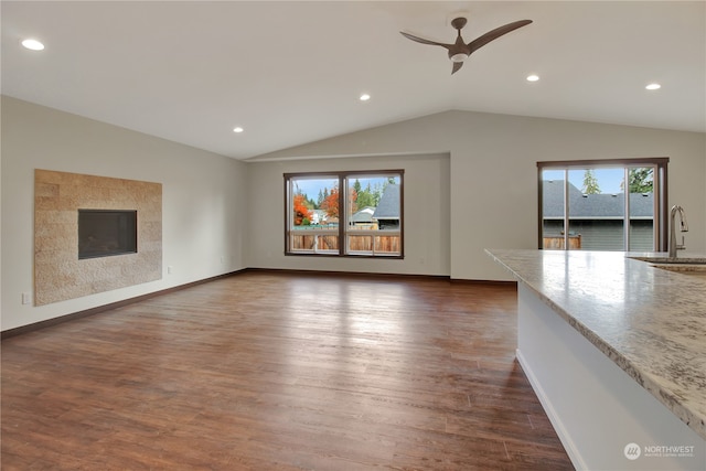 unfurnished living room featuring plenty of natural light, ceiling fan, dark hardwood / wood-style flooring, and sink