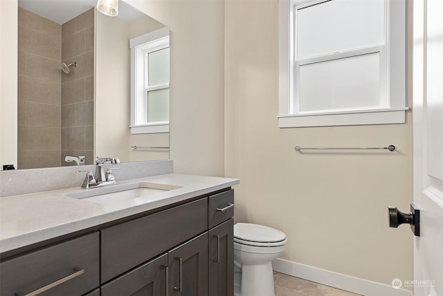 bathroom featuring tile patterned floors, vanity, toilet, and tiled shower