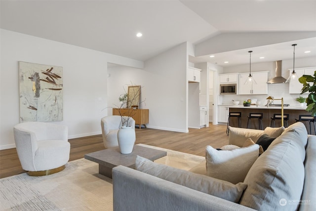 living room featuring light hardwood / wood-style flooring and vaulted ceiling