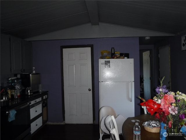 kitchen featuring vaulted ceiling with beams, range, and white refrigerator