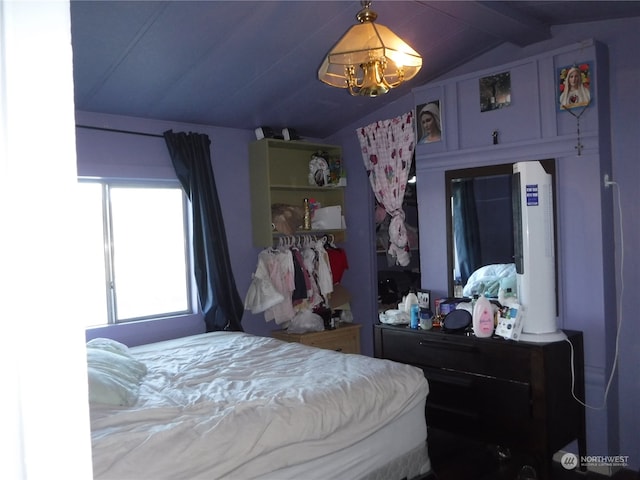 bedroom featuring lofted ceiling and a chandelier