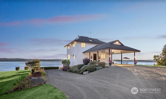 farmhouse inspired home with a water view and a yard