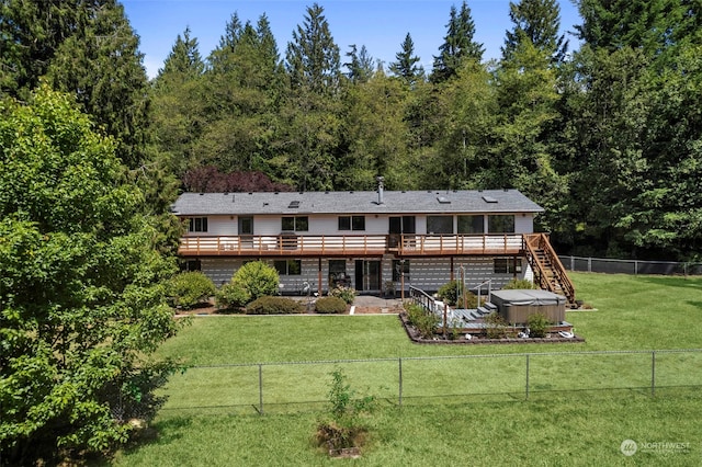 rear view of property with a deck and a yard