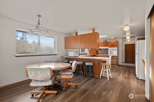 dining room with an inviting chandelier and dark wood-type flooring