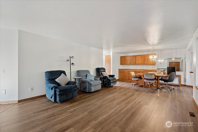 living room with a notable chandelier and light hardwood / wood-style flooring