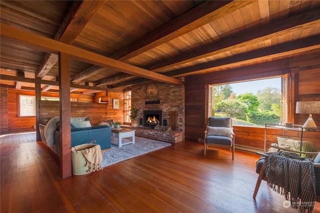 living room with hardwood / wood-style floors, wood ceiling, a fireplace, and wooden walls