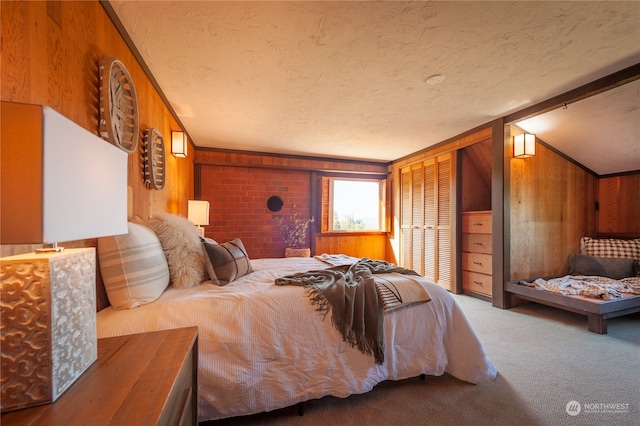 bedroom featuring a closet, wooden walls, carpet, and a textured ceiling