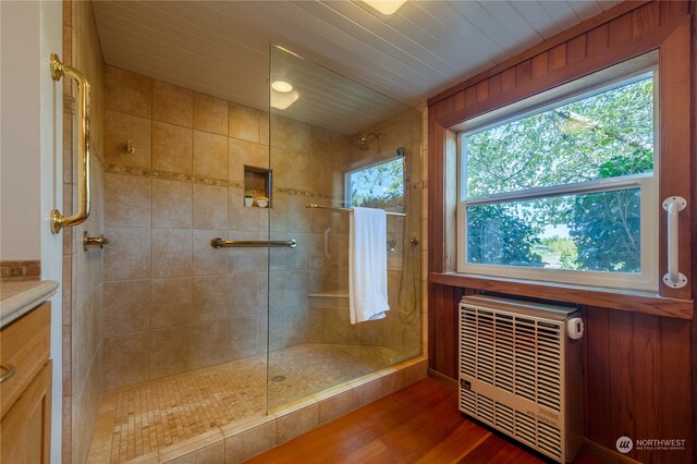 bathroom with hardwood / wood-style floors, a shower with shower door, a wealth of natural light, and vanity