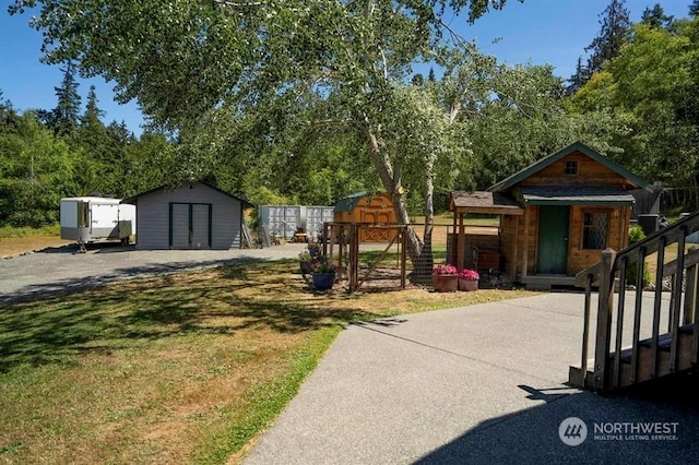 view of front of property with a storage unit and a front yard