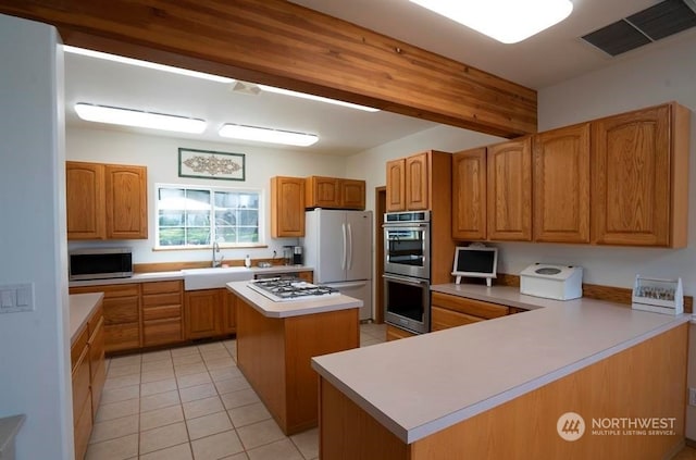 kitchen featuring light tile floors, a kitchen island, sink, and stainless steel appliances