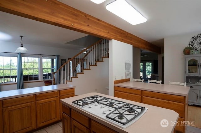 kitchen with white gas cooktop, light tile flooring, and decorative light fixtures