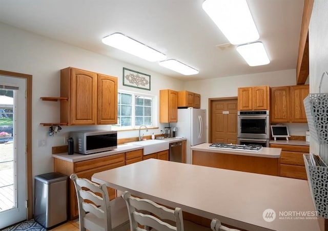 kitchen with a kitchen island, appliances with stainless steel finishes, a breakfast bar area, and sink