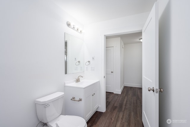 bathroom featuring toilet, vanity, and hardwood / wood-style flooring