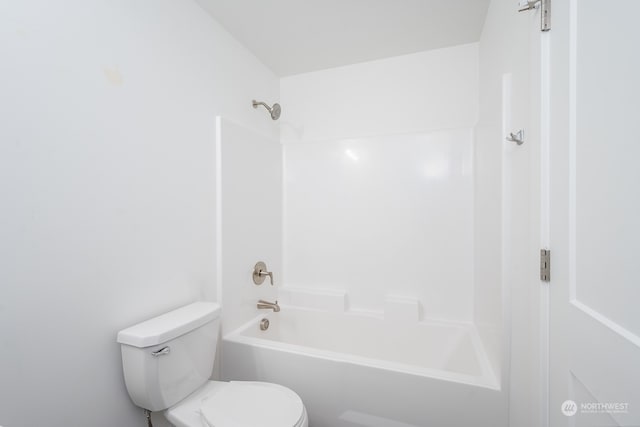 bathroom featuring bathtub / shower combination and toilet