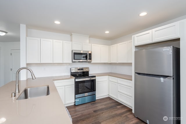 kitchen with dark hardwood / wood-style flooring, white cabinets, appliances with stainless steel finishes, and sink