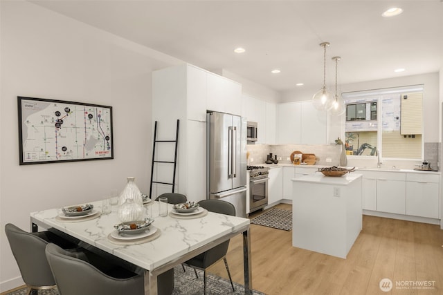 8326C SB-3 13th Ave NW, Seattle, WA 98117 - kitchen with high end appliances, a sink, tasteful backsplash, light countertops, and white cabinetry