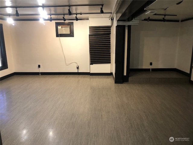 basement featuring hardwood / wood-style floors and a wall unit AC