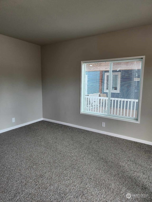 spare room with carpet and baseboards