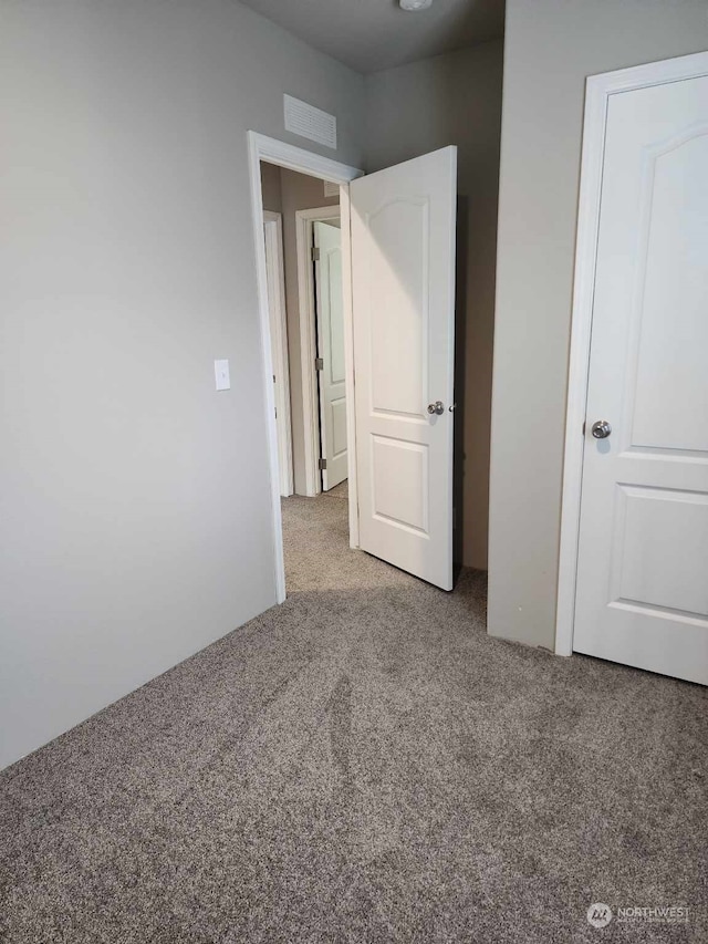 unfurnished bedroom with carpet flooring and visible vents