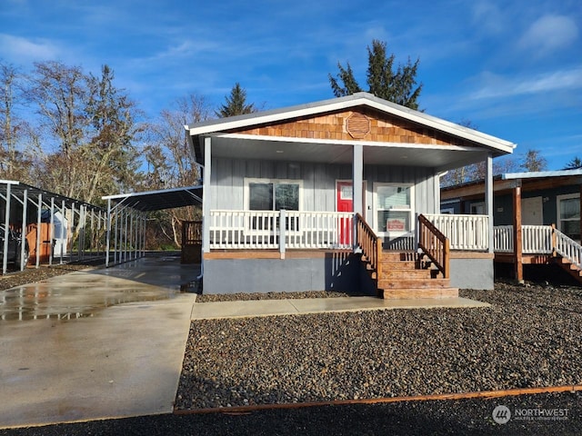 view of front of property with covered porch, driveway, a carport, and board and batten siding