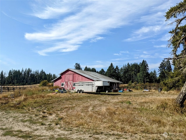 view of yard featuring an outdoor structure and a rural view