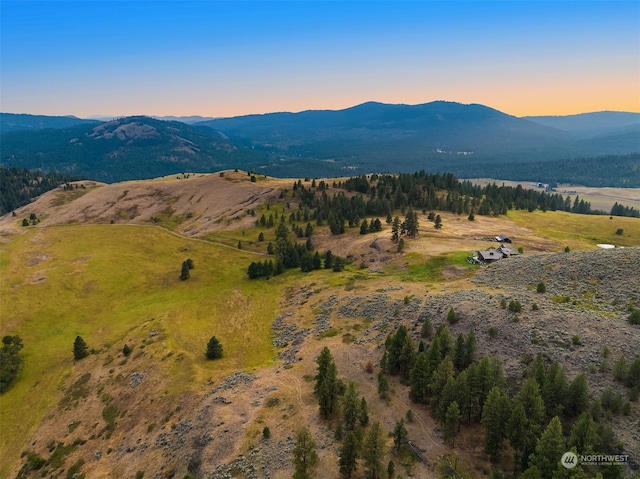 aerial view at dusk featuring a mountain view