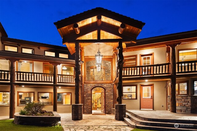 back house at night with a balcony and a patio