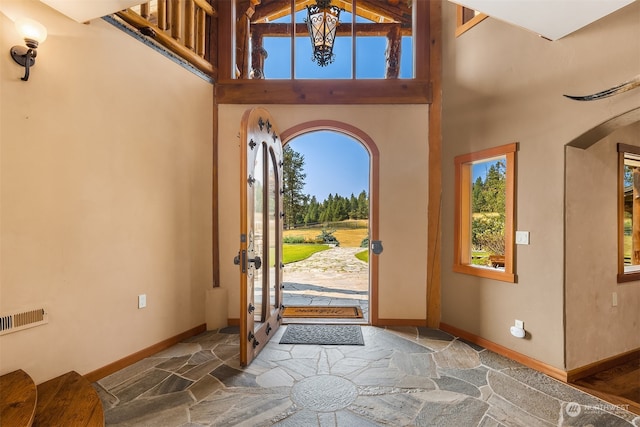 entrance foyer with a towering ceiling and dark hardwood / wood-style floors