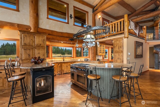 kitchen featuring light hardwood / wood-style flooring, a kitchen island, a breakfast bar, and stone countertops