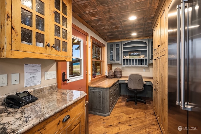 office featuring dark hardwood / wood-style flooring and built in desk