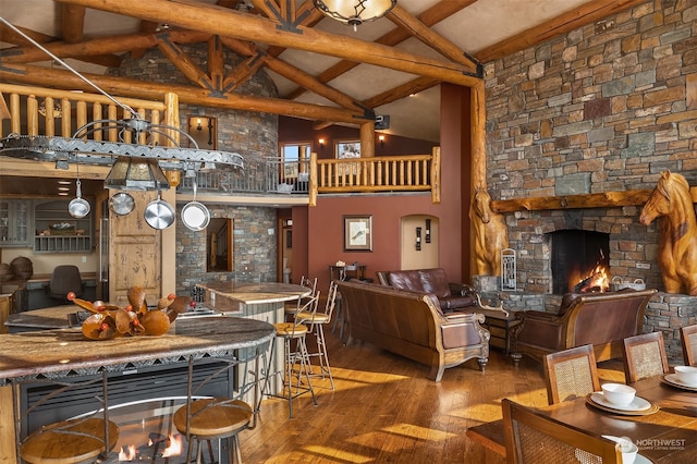 interior space with high vaulted ceiling, a stone fireplace, dark hardwood / wood-style floors, and beamed ceiling